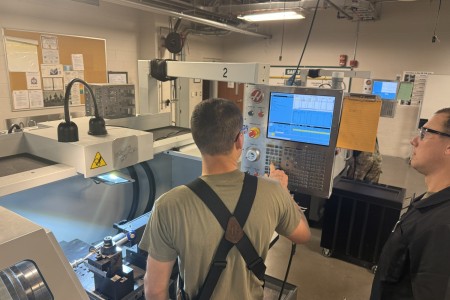 在弗吉尼亚州李堡，陆军中士布兰登·李正在指导二等兵迪伦·坎贝尔如何在数控车床上设置刀具偏移量