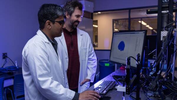 Mujtaba Rafique Ghoto（左）和Christopher O'Bryan正在准备3D打印过程中使用的计算机模型